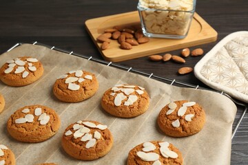 Tasty cookies with almond flakes and nuts on wooden table