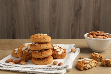 Tasty cookies with almond flakes and nuts on wooden table