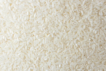 Dry Uncooked White Rice Background - Top View, Flat Lay. Scattered Raw Long Grain Rice. Asian Cuisine and Culture. Healthy Eating Ingredients. Diet Food