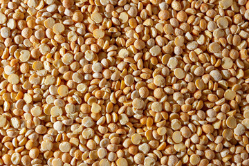 Uncooked Polished Split Peas Background. A Culinary Canvas of Dry Yellow Peas, Creating a Lively and Textured Background for Gourmet Cooking. Scattered Raw Polished Peas. Healthy Eating Ingredients