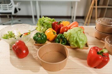 Freshly cut vegetables and salad sitting on a desk with an empty bio box, promoting healthy eating habits at work