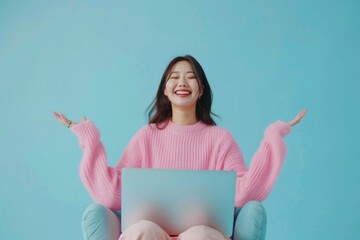 A woman sits in a chair using her laptop for work or personal projects, great for stock photos of remote workspaces or freelancing