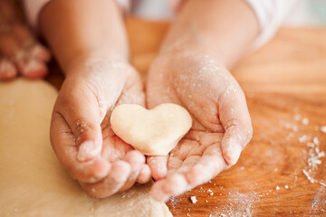 Baking, heart and hands of child with dough for cake, treats and dessert for emoji, shape and...