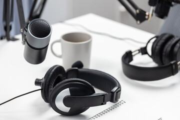 Modern office studio equipment microphone setting, laptop, tablet and headphone prepared with...