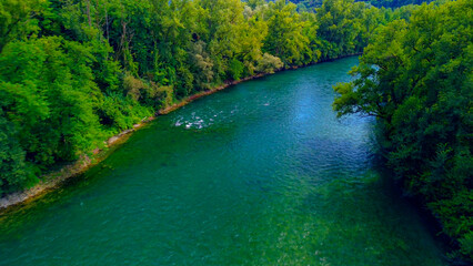 Trezzo sul Adda, Italy. Aerial view of a mountain freshwater river with low water level surrounded by green trees. White swans on the river. Forest. Hydroelectric power station. Green planet. Ecology