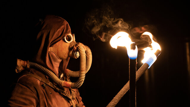 Mann mit Maske und fackeln in der Hand, nah Aufnahme.