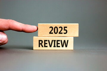 Planning 2025 review new year symbol. Concept words 2025 Review on beautiful wooden blocks. Beautiful grey background. Businessman hand. Business 2025 review new year concept. Copy space.