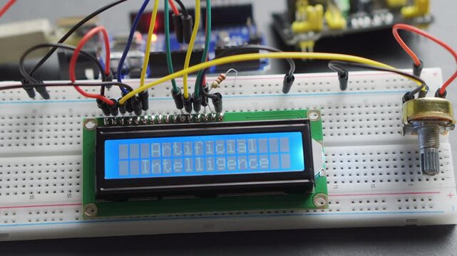 Electronic display with the inscription Artificial intelligence. Electrical components with a microcontroller and wires. Arduino prototype
