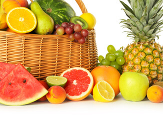 Many different fresh fruits in wicker basket isolated on white