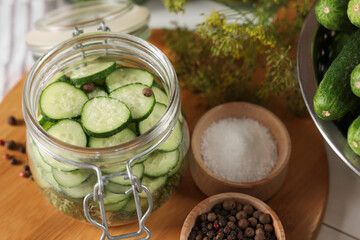 Homemade pickles. Fresh cucumbers in jar and spices on table, closeup