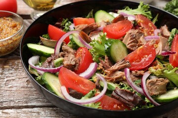 Delicious fresh tuna salad on wooden table, closeup
