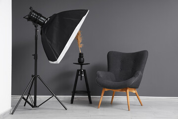 Modern photo studio with armchair and professional lightening equipment