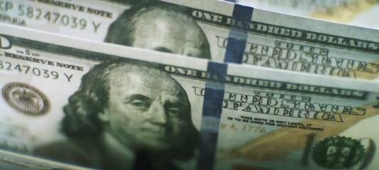 Electronic money counter machine counts American one hundred dollar banknotes in slow-motion. Financial control of cash income - Powered by Adobe