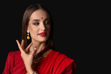 Beautiful young happy Indian woman in sari on black background