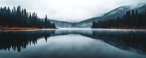Beautiful lake in misty morning. Mountains, forest and clouds reflected in the calm water surface. Norwegian dark autumn landscape. Nature, ecology, eco tourism. Travel and vacation concept