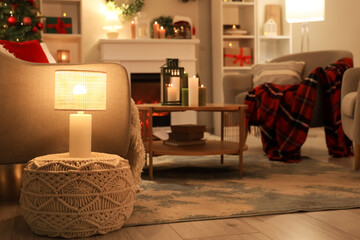 Interior of dark living room with Christmas decor and glowing lamps