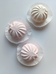 white and pink marshmallow on a gray background
