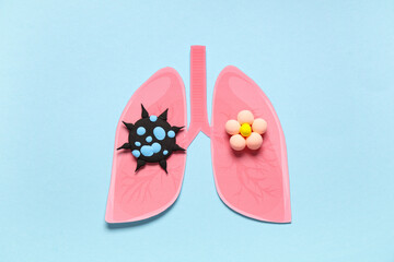 Paper lungs with plasticine virus on blue background