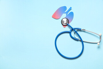 Paper lungs with stethoscope on blue background