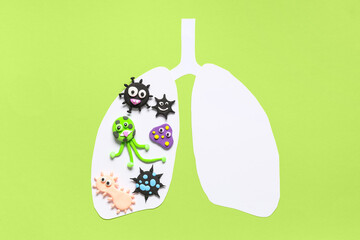 Paper lungs with plasticine viruses on green background