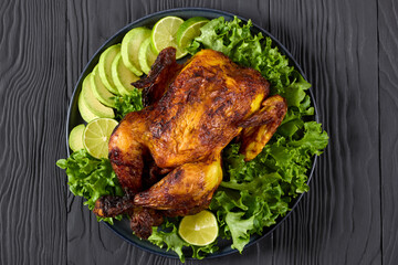 whole roasted chicken with avocado, lime on plate