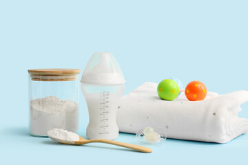 Bottle with baby milk formula, pacifier, rattle and pillow on color background