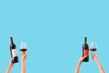 Female hands holding glasses and bottles of wine on blue background