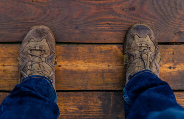 Wanderer's perspective on weathered wooden floor captured during an outdoor adventure in a serene...