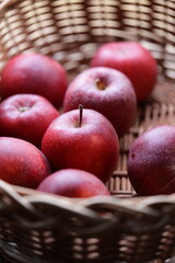 Fresh red apples in a woven wicker basket, ideal for still life photography or as a prop in food and drink scenes.