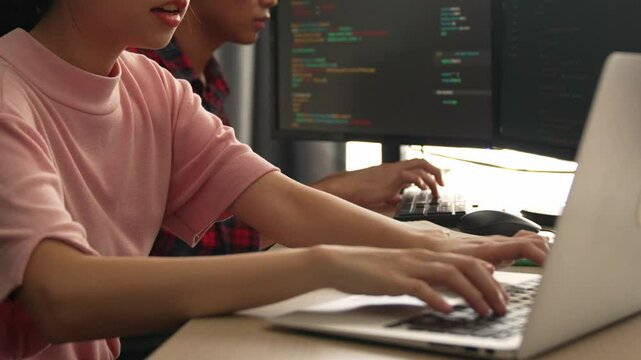 Slow motion back end software developer engineer for computer programming working together on debugging writing computing code, solving complex algorithms display on monitor in office. Burgeoning