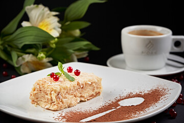 Plate with dessert, artistically presented on a black background framed by vegetables and flowers. Culinary art. Food artistry