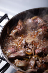 Chicken livers are being cooked with onions.