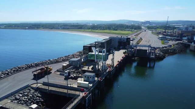 Aerial view of a maritime landing stage with a suspended glass access ramp and a particular cubic architecture.