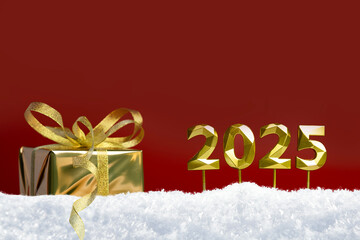 New Year's background. The numbers 2025 and a gift on a red background in the snow.