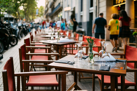 Fototapeta Outdoor Cafe in Barcelona with Empty Tables and Street Scene