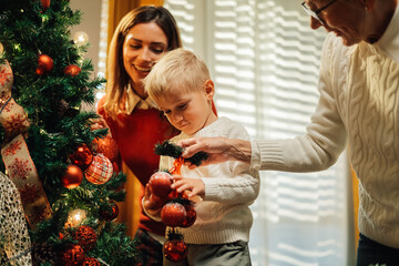 Happy family decorating christmas tree at home