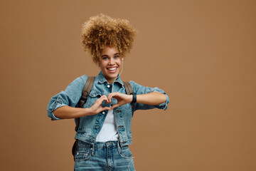 Young happy woman doing heart gesture with her hands and looking at camera.
