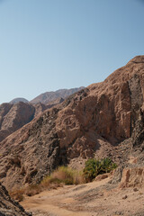 mountain range landscape. The mountains are characterized by sharp rocky outcroppings and steep slopes covered with rocks and little vegetation. The colors of the mountains range from dark brown to li