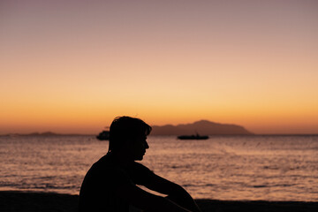 Shadow of a man at sunset on the seashore or ocean
