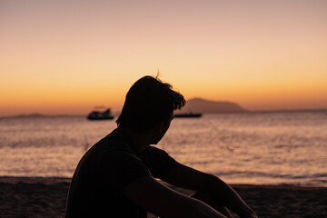 Shadow of a man at sunset on the seashore or ocean