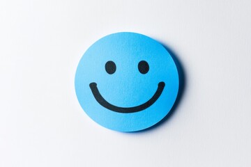 Fototapeta premium A blue sticky note with a black smiley face drawn on it.