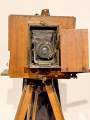 Antique bellows camera in wooden case in white background