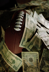 A football covered in a pile of money