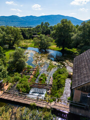Naklejka premium Aerial view of Gacka river valley, surrounded by mountains and forests in mountain region of Lika, Croatia