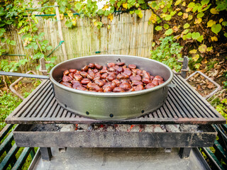 Popular autumn delicacy, baked chestnuts on the hot charcoal in the pan