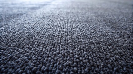 Soft textured fiber dark gray carpet background seen from low angle