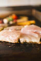 A close-up of tender fish fillets plated with vibrant grilled vegetables. This image highlights a fresh and nutritious meal, perfect for menus, food blogs, or health-focused content.