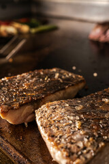 A close-up of a perfectly grilled fish fillet, shows its crispy exterior and juicy texture. The grill marks add an appealing touch, highlighting the cooking technique.