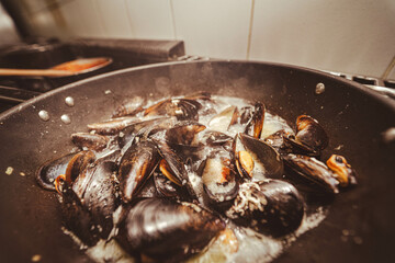 A vibrant display of fresh shellfish, including shrimp and mussels, sizzling in a pan. Ideal for seafood menus, culinary blogs, or restaurant promotions, this image captures the essence of seafood.