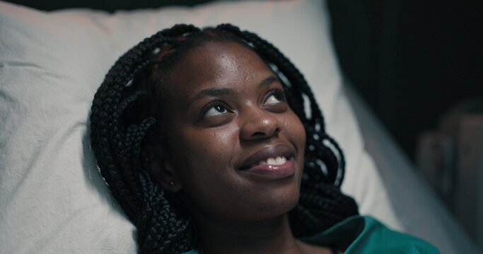 African woman patient, deep in thought, her gaze fixed above.